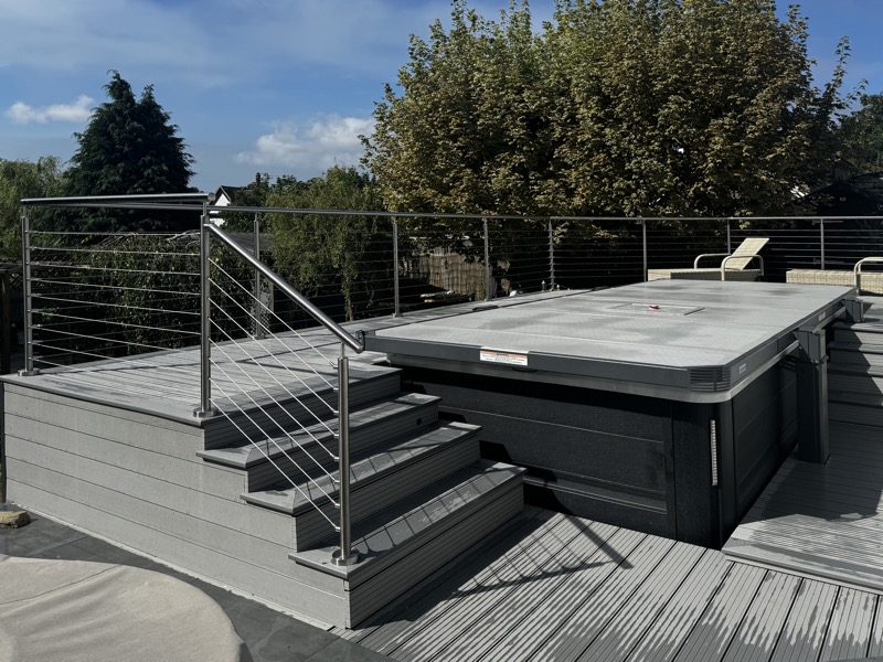 Hot tub on composite decking with stainless steel balustrade and cover over pool